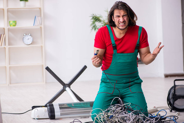 Funny joven electricista masculino trabajando en interiores
 - Foto, Imagen