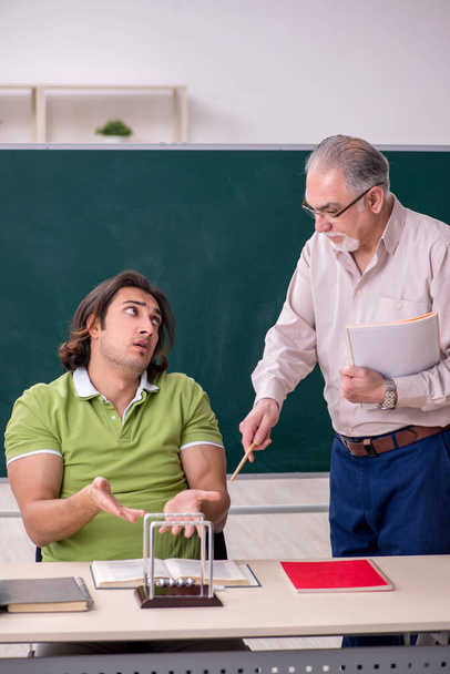 Old professor physicist and young student in the classroom - Photo, Image