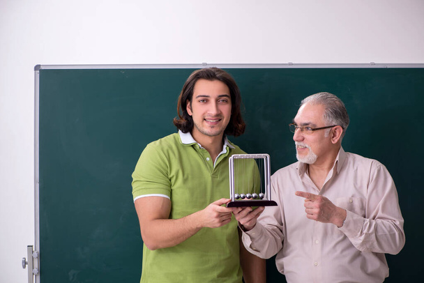 Régi professzor fizikus és fiatal diák az osztályteremben - Fotó, kép