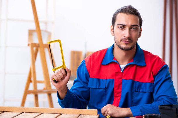Joven contratista masculino trabajando en taller
 - Foto, imagen