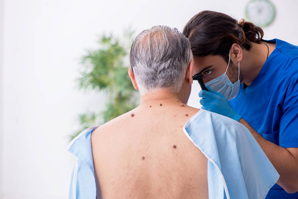 Öreg férfi látogató fiatal férfi orvos bőrgyógyász - Fotó, kép