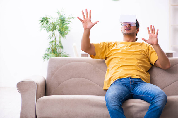Νεαρός άνδρας με γυαλιά εικονικής πραγματικότητας στο σπίτι - Φωτογραφία, εικόνα