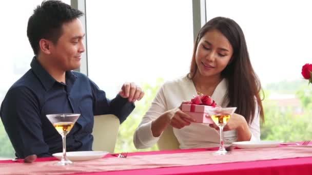 Romanttinen pari antaa lahja rakastaja ravintolassa - Materiaali, video
