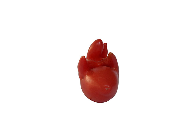 Eine unregelmäßig geformte Tomate mutierte infolge ungünstiger Wachstumsbedingungen. Isoliert auf weißem Hintergrund. - Foto, Bild