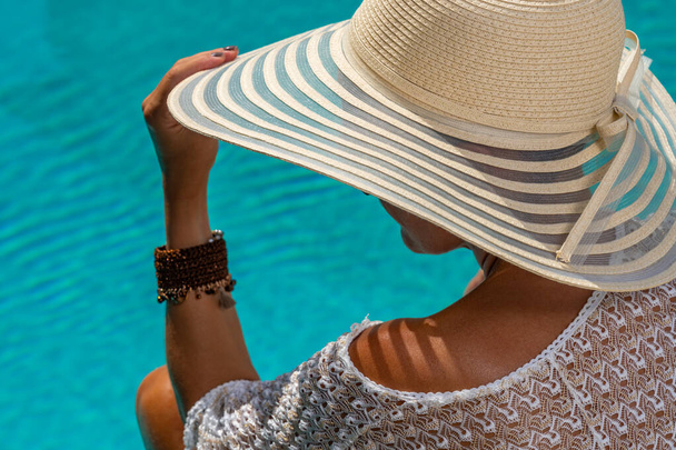 woman with straw hat in luxury five stars  spa resort by the swimming pool.  - Fotoğraf, Görsel