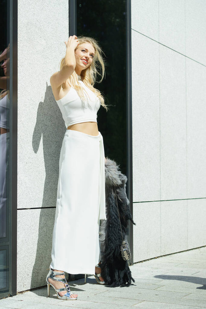 Elegant fashionable woman presenting trendy urban outfit. White crop top and trousers culottes. - Photo, Image