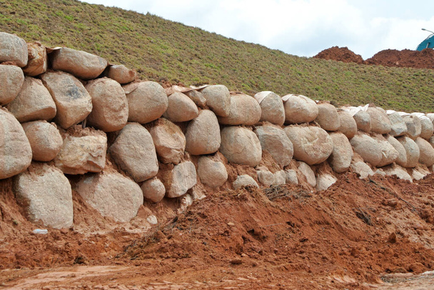 Stone boulders are stacked on the ground and used as retaining walls. It acts to resist soil erosion caused by rain. - Photo, Image
