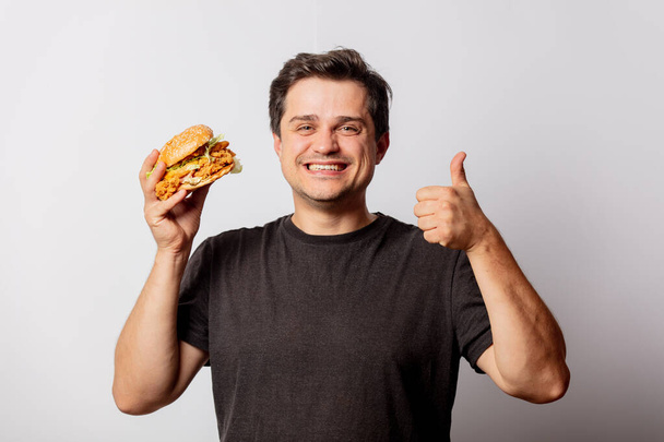 Homem branco em camisa preta com hambúrguer no fundo branco  - Foto, Imagem