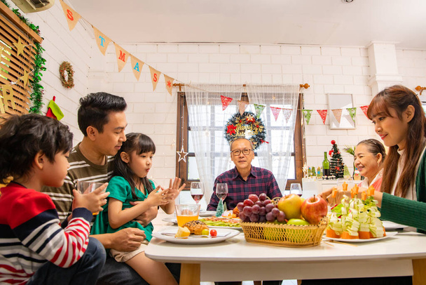 Thanksgiving or christmas Celebration Asian  Family Dinner Concept.Happy family having holiday dinner. father mother and daughter, having dinner at home. elderly parents during the celebration . - Zdjęcie, obraz