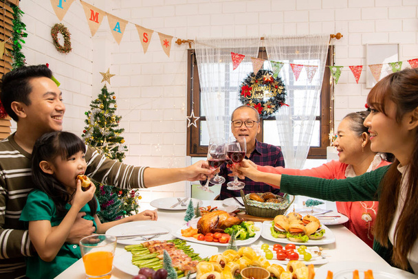 Thanksgiving or christmas Celebration Asian  Family Dinner Concept.Happy family having holiday dinner. father mother and daughter, having dinner at home. elderly parents during the celebration . - Фото, зображення
