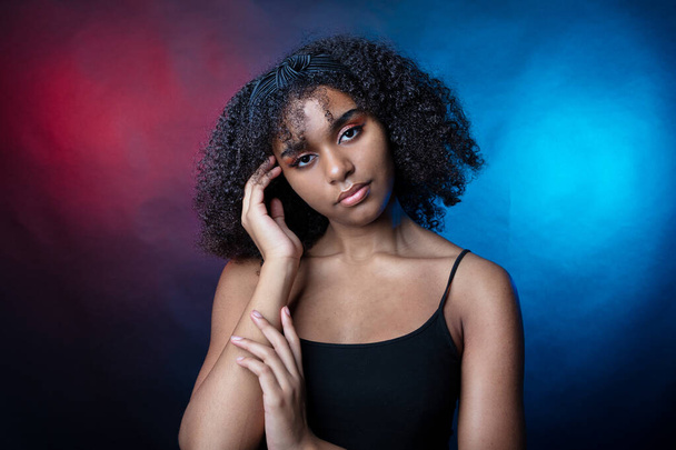 Πορτραίτο ενός μαύρου κοριτσιού στο στούντιο σε σκούρο φόντο - Φωτογραφία, εικόνα