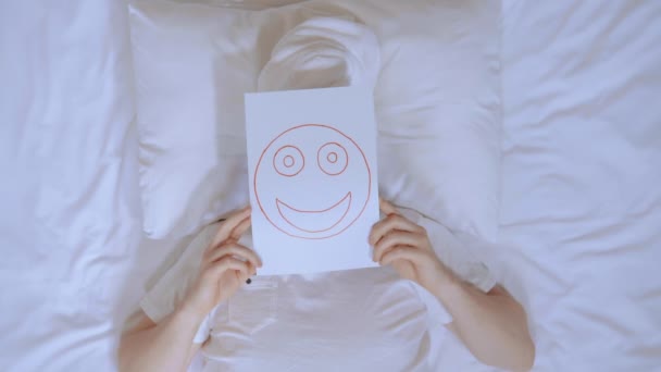 Mies, jolla on naama pakkaus leikkimässä sängyssä - Materiaali, video