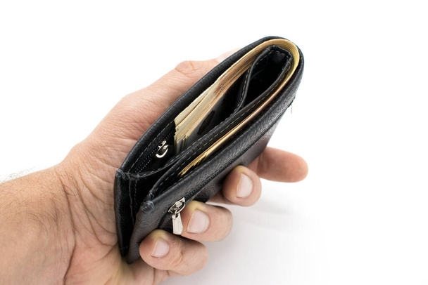 A purse with money on a white background and a hand that counts bills. - Foto, afbeelding