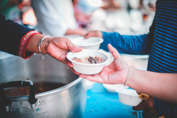 Doar comida para as pessoas na sociedade: As mãos dos pobres recebem comida das mãos do filantropo - Foto, Imagem