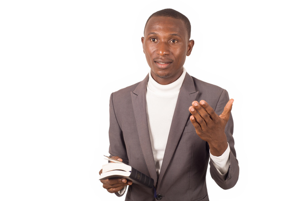 πορτρέτο του νεαρού άνδρα με κοστούμι στέκεται κρατώντας μια Βίβλο και κήρυγμα με χειρονομίες. - Φωτογραφία, εικόνα