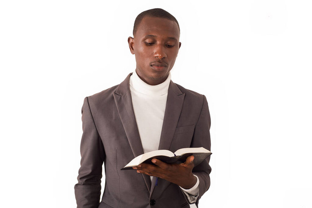 retrato do jovem pastor de pé e lendo uma Bíblia em sua mão. - Foto, Imagem