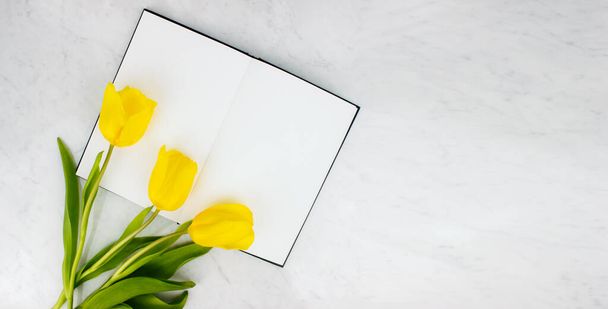 Bouquet di tulipani gialli disteso piatto su sfondo marmoreo vista dall'alto con spazio copia. Fiori primaverili. 8 marzo, giorno di Pasqua. - Foto, immagini