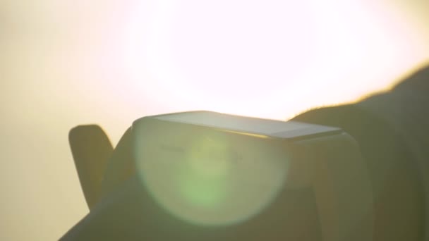Slow motion: vrouw met witte smartwatch tegen warme zonsondergang hemel - close-up - Video