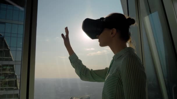 Fiatal nő virtuális valóság headset ellen felhőkarcoló ablak - VR koncepció - Felvétel, videó