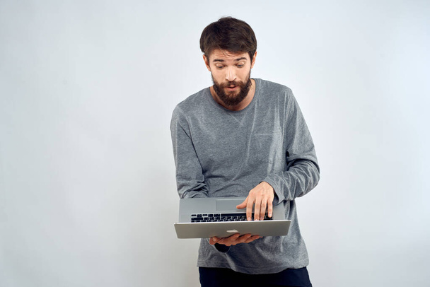 Un homme tenant un ordinateur portable communication internet style de vie technologie lumière arrière-plan studio - Photo, image