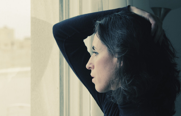 γυναίκα στέκεται κοντά σε παράθυρο - Φωτογραφία, εικόνα