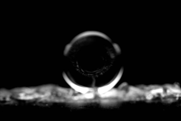 Wazig beeld van een ronde glanzende cirkel in vervaging. Rond wazig glanzend object in zwart-wit. - Foto, afbeelding