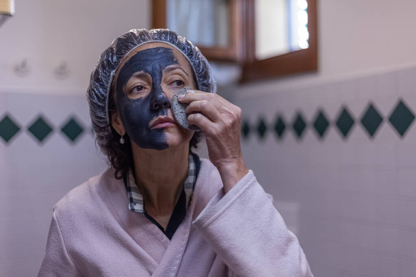 Женщина снимает маску с губки - Фото, изображение