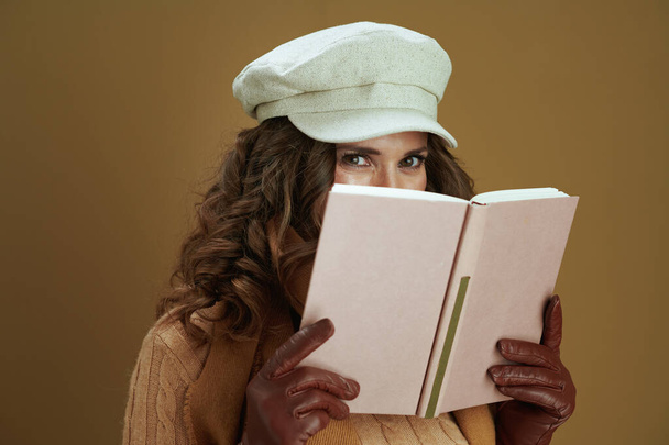 Привіт листопад. елегантна жінка в шарфі з книгою і шкіряними рукавичками ізольована на бежевому
. - Фото, зображення