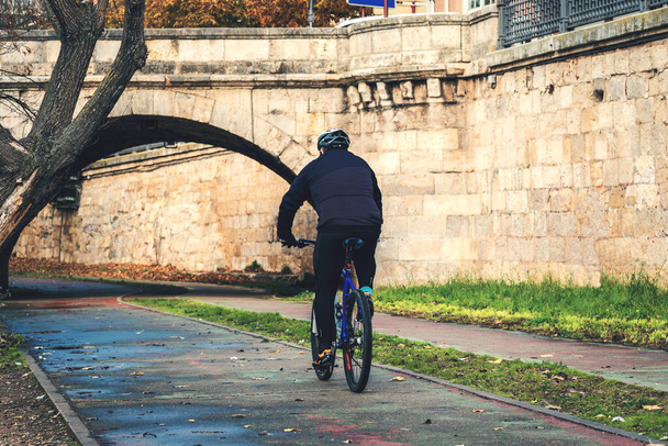 estilo de vida saludable, hombre con equipo deportivo montar la bicicleta en el parque durante el otoño. Palencia, España - Foto, imagen
