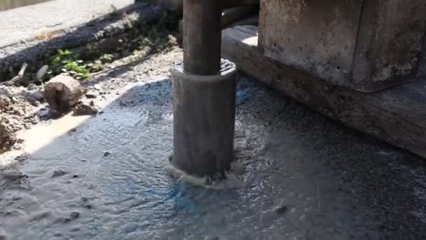 Detalhe de máquinas de perfuração rotativa em ação com água saindo do subsolo - Filmagem, Vídeo