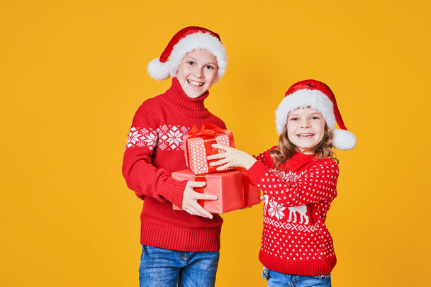 Happy children holding red gift boxes - Fotoğraf, Görsel