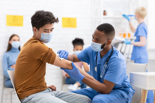 Paciente masculino asiático vacunándose contra el coronavirus en el hospital - Foto, imagen