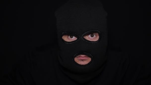 黒い服を着た男、中に入るマスクと手袋、周りを見て彫刻を盗む。面白く愚かな強盗だ. - 映像、動画