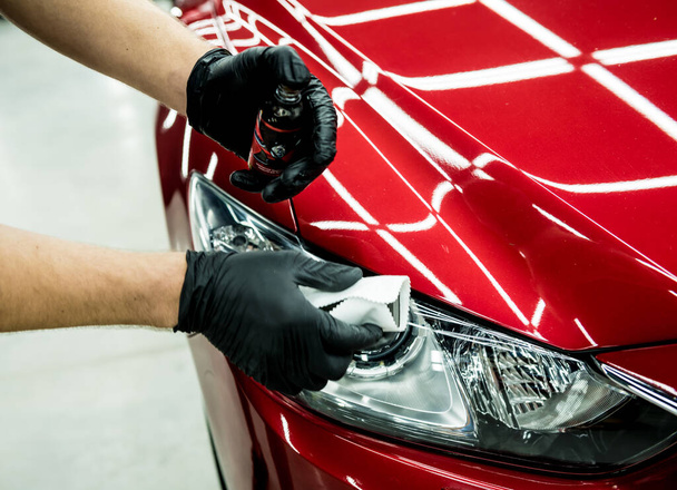 Car service worker applying nano coating on a car detail. - Фото, изображение