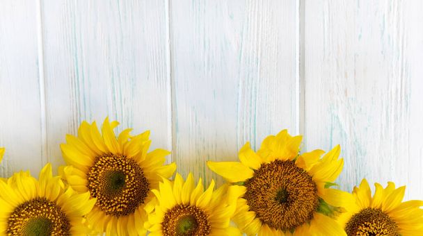 Postcard with flowers of a sunflower on a light wooden background. Frame for text for Thanksgiving, birthday. Background with autumn flowers for website, banner - Fotó, kép
