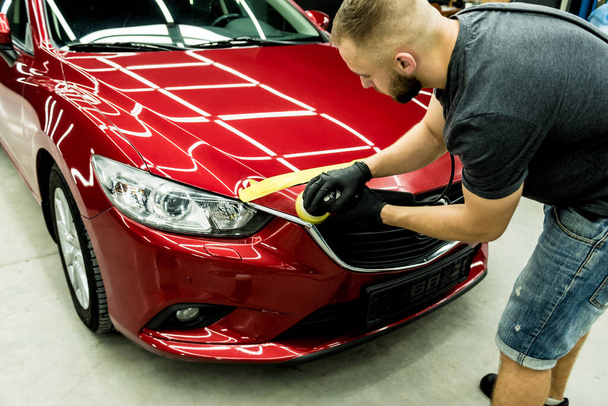 Car service worker polishes a car details with orbital polisher. - Foto, immagini