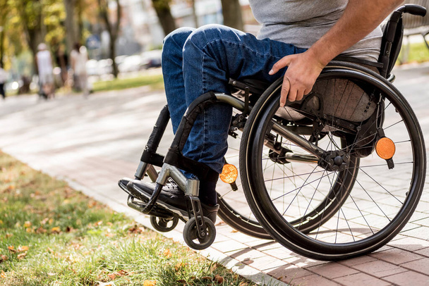 Handicapped man in wheelchair walk at the park alley - Fotó, kép