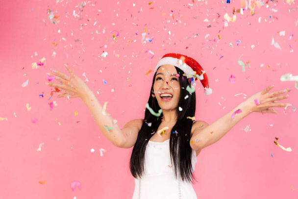 Portrait of two lovely cute asian women in christmas hats  looking at camera isolated over pink background.Attractive asian woman smile in christmas, new year, valentine day, birthday celebration concept. - Fotoğraf, Görsel