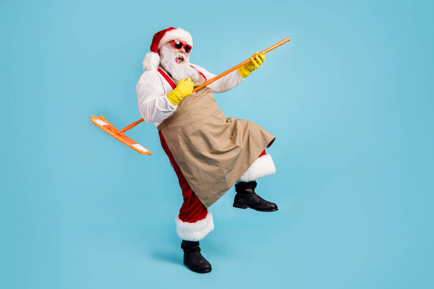Full length body size view of his he nice attractive glad cheerful Santa cleansing floor doing domestic housework playing mop like guitar isolated bright vivid shine vibrant blue color background - Photo, image
