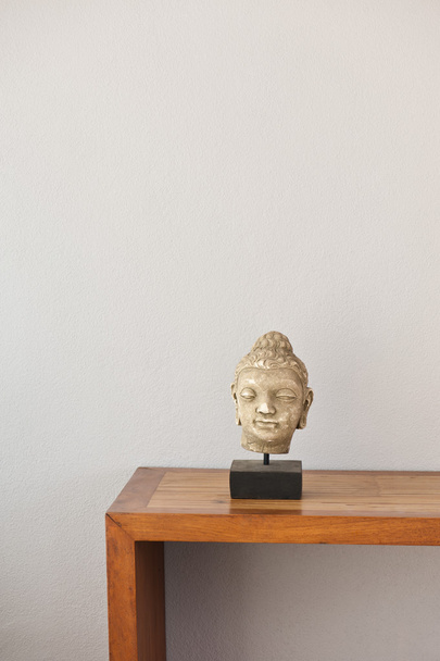 Buddha head in front of a grey wall - Photo, Image