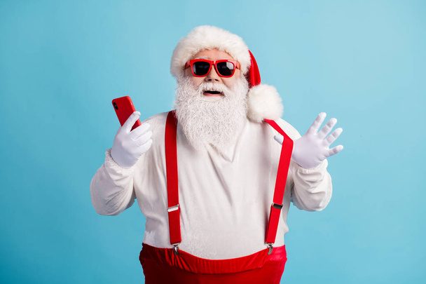 Portrait of his he nice attractive cheerful cheery white-haired Santa using device 5g app social network blogging shop order sale having fun isolated bright vivid shine vibrant blue color background - Fotó, kép