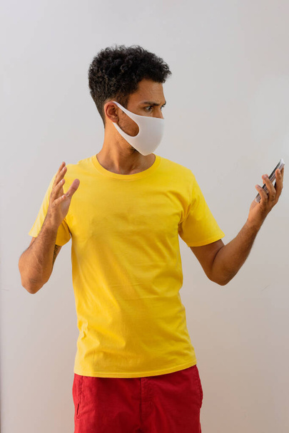Hombre negro con máscara pandémica sosteniendo una tarjeta de trabajo brasileña, fondo blanco aislado - Foto, Imagen