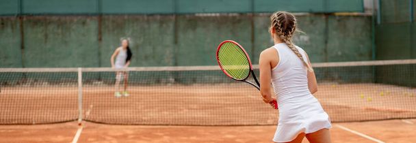 Jugador de tenis profesional jugando al tenis en una cancha de tenis de arcilla en un día soleado - Foto, Imagen