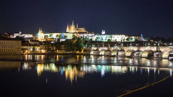 Pargue Charles bridge and prague castle by night reflections river - Фото, изображение