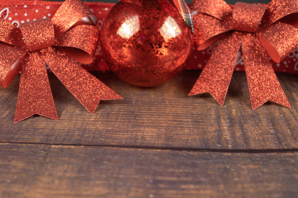 bola de Navidad y cintas rojas sobre un fondo de madera. decoraciones de Navidad - Foto, Imagen