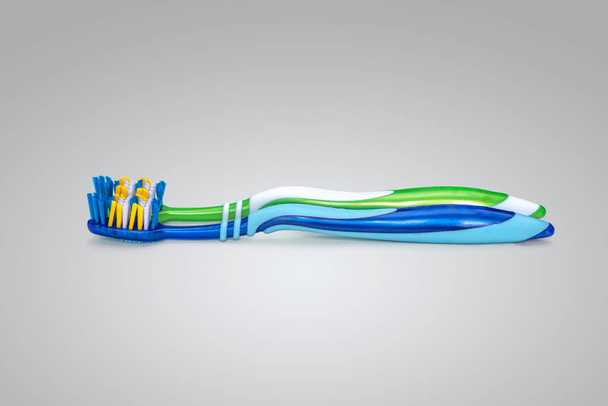 Δύο νέες πλαστικές οδοντόβουρτσες, πράσινες και μπλε σε λευκό φόντο - Φωτογραφία, εικόνα