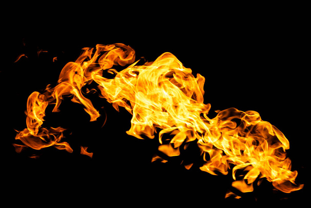 Πυρκαγιά φλόγες σε μαύρο φόντο απομονώνονται. Καύση αερίου ή βενζίνης καίει με φωτιά και φλόγες. Φλεγόμενες σπίθες φωτιάς από κοντά, μοτίβα φωτιάς. Διαβολική λάμψη φωτιάς στο σκοτάδι με αντιγραφικό χώρο - Φωτογραφία, εικόνα