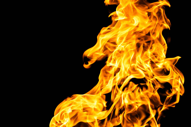 黒い背景に炎が隔離された。燃焼ガスやガソリンは火と炎で燃えます。炎の燃える火花を閉じると、火災のパターン。暗闇の中の火の無限の輝きをコピースペースで - 写真・画像