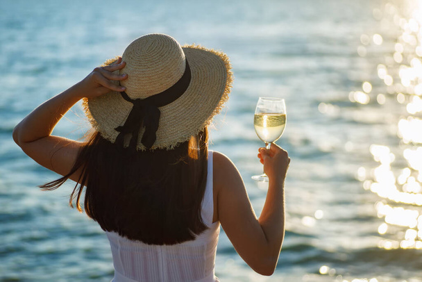 woman holding glass of wine by the sea - Foto, Imagem
