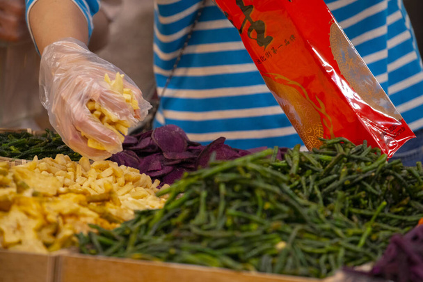 人々は新年の前に有名な台北新年通りで乾燥した果物や野菜を購入します - 写真・画像